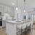 a kitchen with a large island and chairs