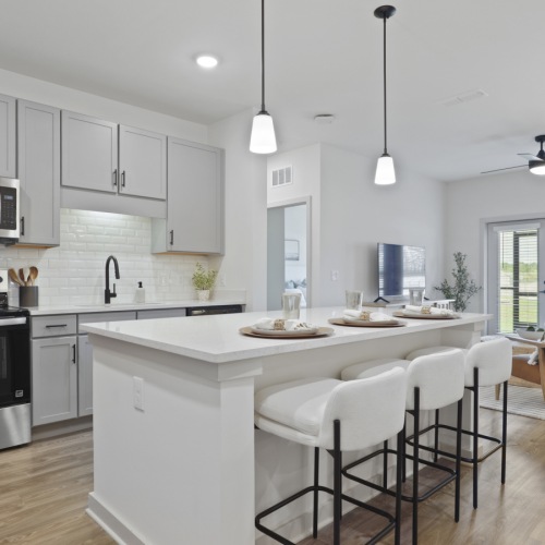 a kitchen with a large island and chairs
